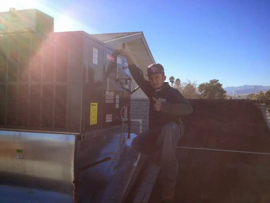 HVAC technician performing Boiler Repair on a rooftop unit in Havre